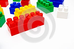 Many colorful toy plastic bricks, kit of blocks for building and constructing on white background with copy space