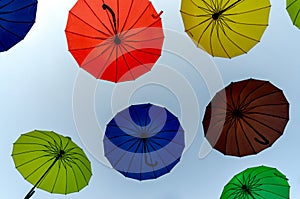 many colorful umbrellas fly and hover on the city street