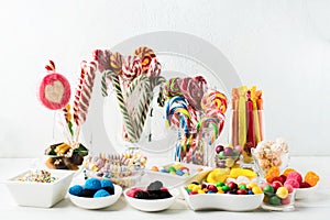 Many colorful unhealthy sweets - candy canes, jelly. Sweet mix desserts for Birthday, Christmas or Halloween photo