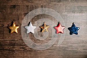 Many colors of Metallic stars such as red, blue, golden and silver on wooden background for Christmas and Happy New Year.