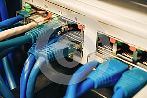 Many communication Internet wires are connected to network interfaces. Telecommunication cables are in the ports of the office