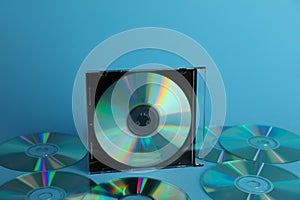 Many compact discs on light blue background