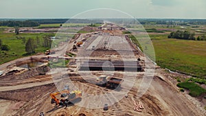 Many construction machines working on a new highway in the middle of nowhere. Changing the landscape.