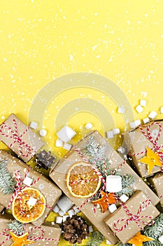 Many craft gift boxes on Illuminating yellow background. Christmas holiday zero waste banner with snow flakes