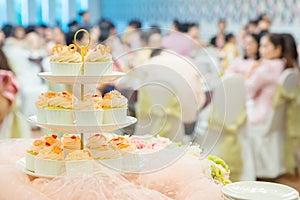 many cupcakes on shelf shelves in wedding party. dessert serving for wedding guest. sweets mini cakes.