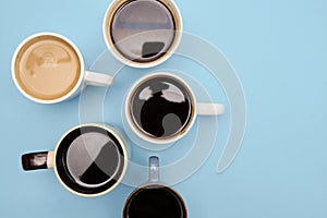 Many cups of different aromatic hot coffee on blue background, top view