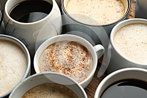 Many cups of different coffees on wooden table, closeup
