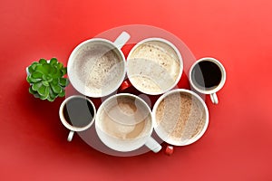 Many cups with tasty aromatic coffee on color background, flat lay