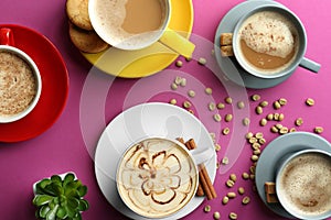 Many cups with tasty aromatic coffee on color background, flat lay