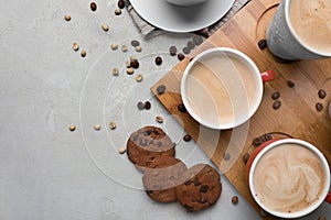 Many cups with tasty aromatic coffee and cookies on grey table