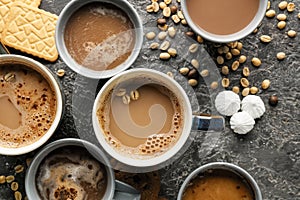 Many cups with tasty aromatic coffee and cookies on grey table, flat lay