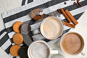 Many cups with tasty aromatic coffee and cookies on white table