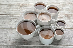 Many cups with tasty aromatic coffee on wooden table