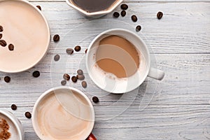 Many cups with tasty aromatic coffee on wooden table