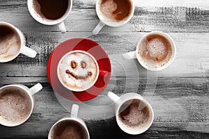 Many cups with tasty aromatic coffee on wooden table, flat lay