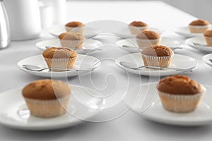 Many delicious muffins served on white table for coffee break