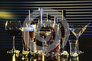 Many different alcoholic drinks on table against dark background photo