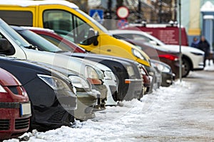 Many different cars parked in a city. Cars for sale