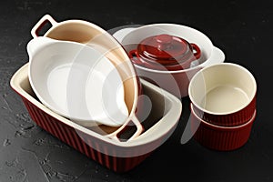 Many different casseroles on black table, closeup