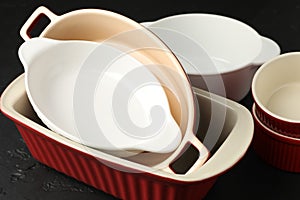 Many different casseroles on black table, closeup