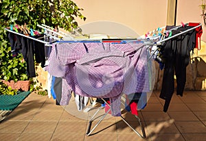 many different clothes holding in washing line at a garden in a sunny day
