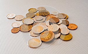 Many different coins from different countries from the black wallet are scattered around the table: dollars, pounds, rubles, penni