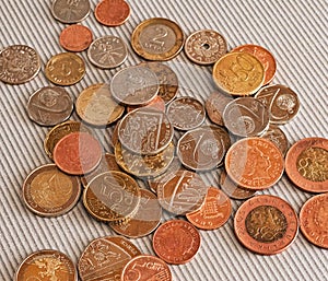 Many different coins from different countries from the black wallet are scattered around the table: dollars, pounds, rubles, penni