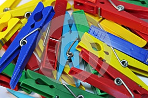 Many different colored plastic clothes pegs close up