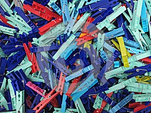 Many different colored plastic clothes pegs close up. Lots of clothespins