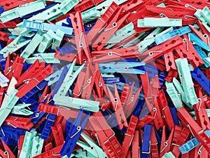 Many different colored plastic clothes pegs close up. Lots of clothespins