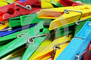 Many different colored plastic clothes pegs close up