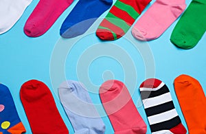 Many different colorful socks on light blue background, flat lay