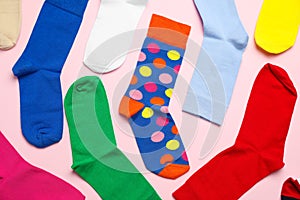 Many different colorful socks on light pink background, flat lay