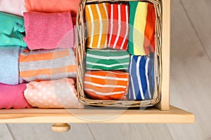 Many different colorful socks in open drawer