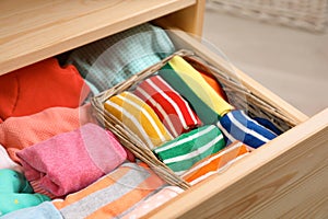 Many different colorful socks in open drawer