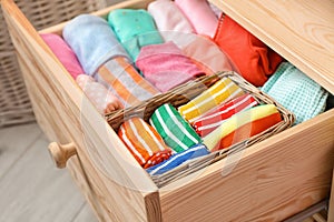 Many different colorful socks in open drawer
