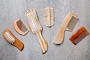 Many different combs and hairbrushes on grey background, flat lay