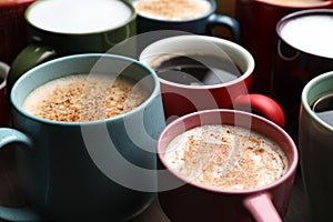 Many different cups with aromatic hot coffee on table, closeup