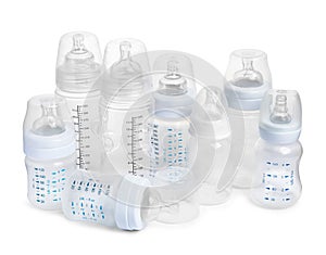 Many different empty feeding bottles for baby milk on white background