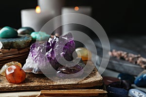 Many different gemstones and blurred candles