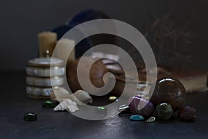 Many different gemstones on the blurred mirrors and  candles background