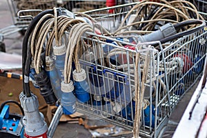 Many different IEC 60309 style plugs with cables in the cart.