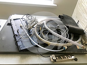 Many different industrial hoses and wires lie on the table