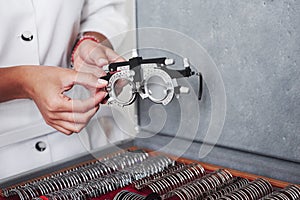 Many of different lenses below. Female hands holding the optical device for eye testing