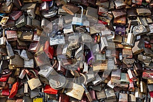 many different metal padlocks on a wall of each other