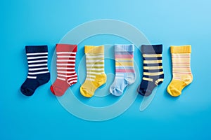 Many different mismatched baby kid socks on light blue background. Odd Socks Day, Lonely Sock Day, Anti-Bullying Week