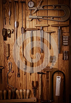 Many different old tools hanging on wall