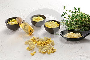 Many different pills with bottle of essential oil and thyme on white table