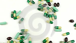 Many different pills fall on a white background. Faster shooting. Selective focus on pills, vitamins, medicines, capsules, medicin