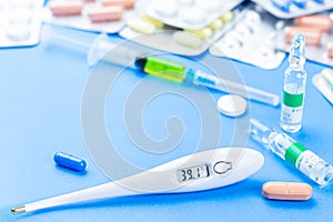 Many different pills, medical thermometer wiht high temperature covid-19 concept picture